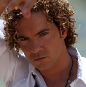 A photograph of David Bisbal with his long curly hair in a Hanging